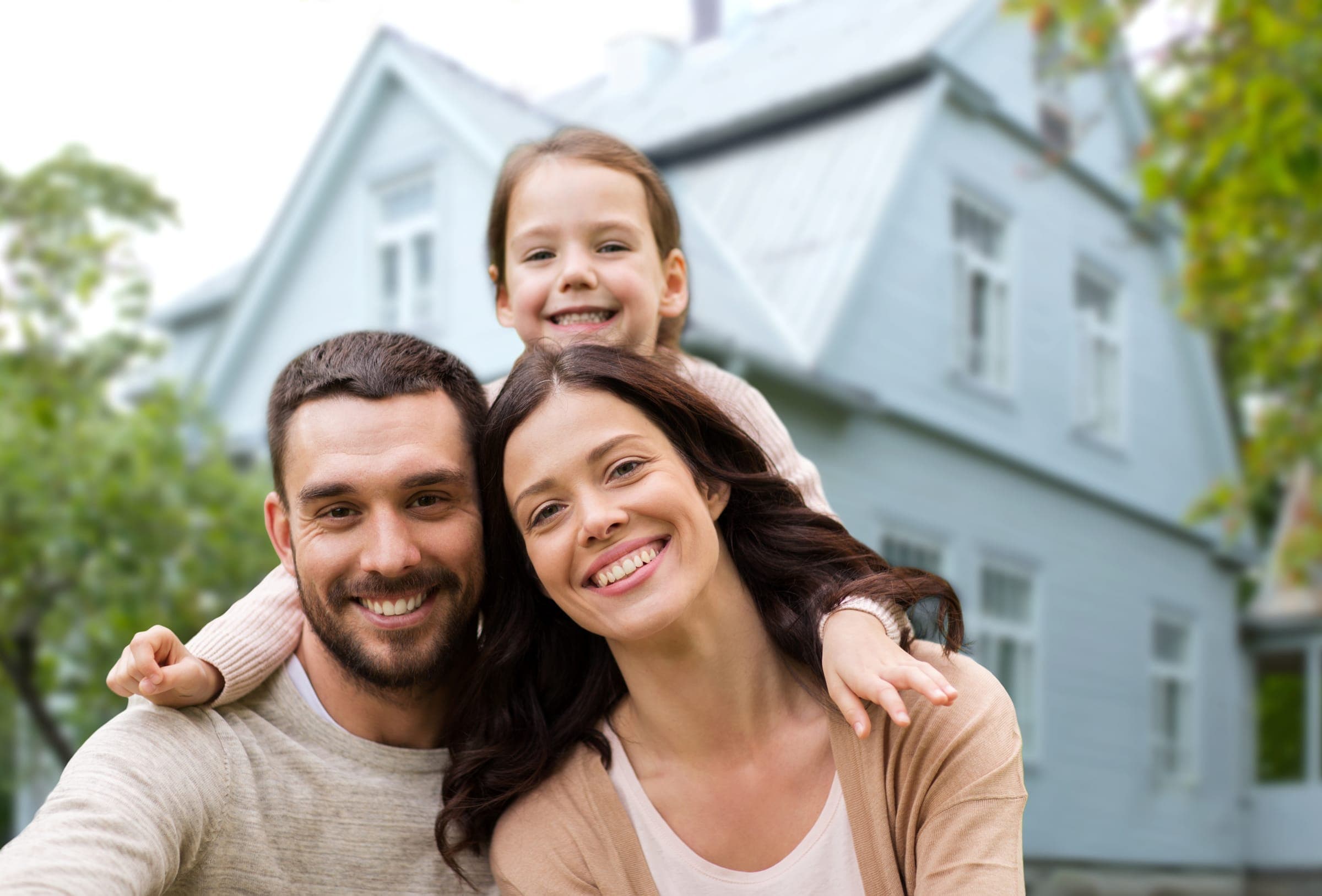 Famille souriante devant sa maison